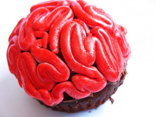 A cupcate with red icing that makes it look like a brain.