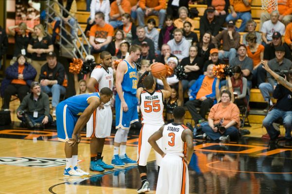 College basketball player shooting a foul shot while fans look on.