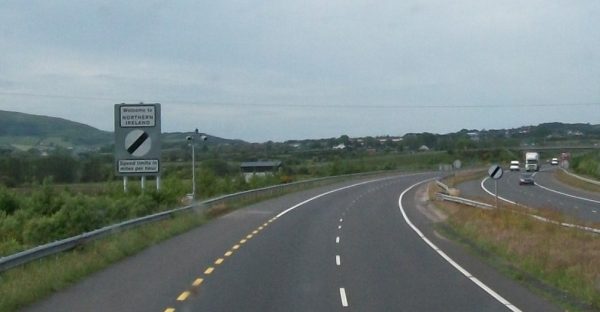 Photo of a highway with a sign by the side of the road that says, welcome to northern ireland